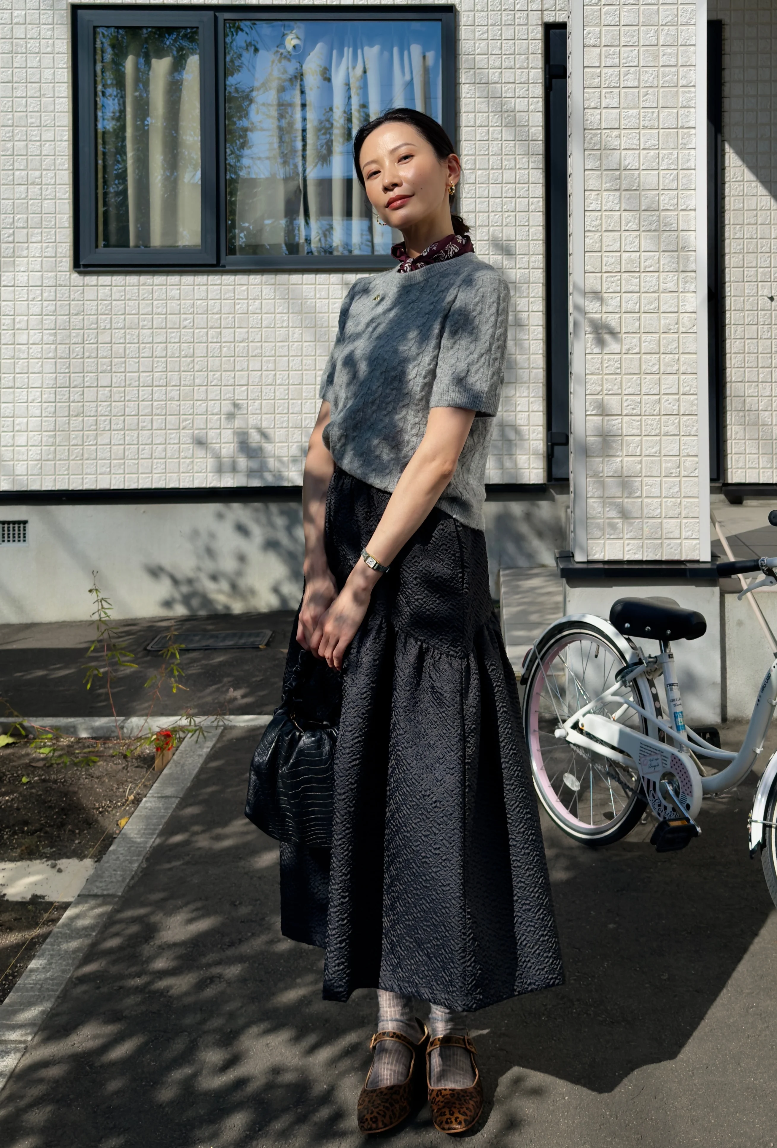Elegant Textured Black Skirt and Gray Top with Bold Accessories