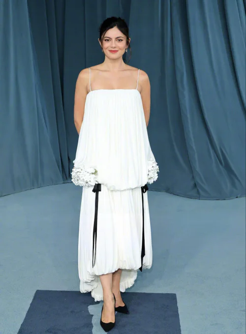Monica Barbaro. Ethereal White Dress with Black Accents and Floral Detailing