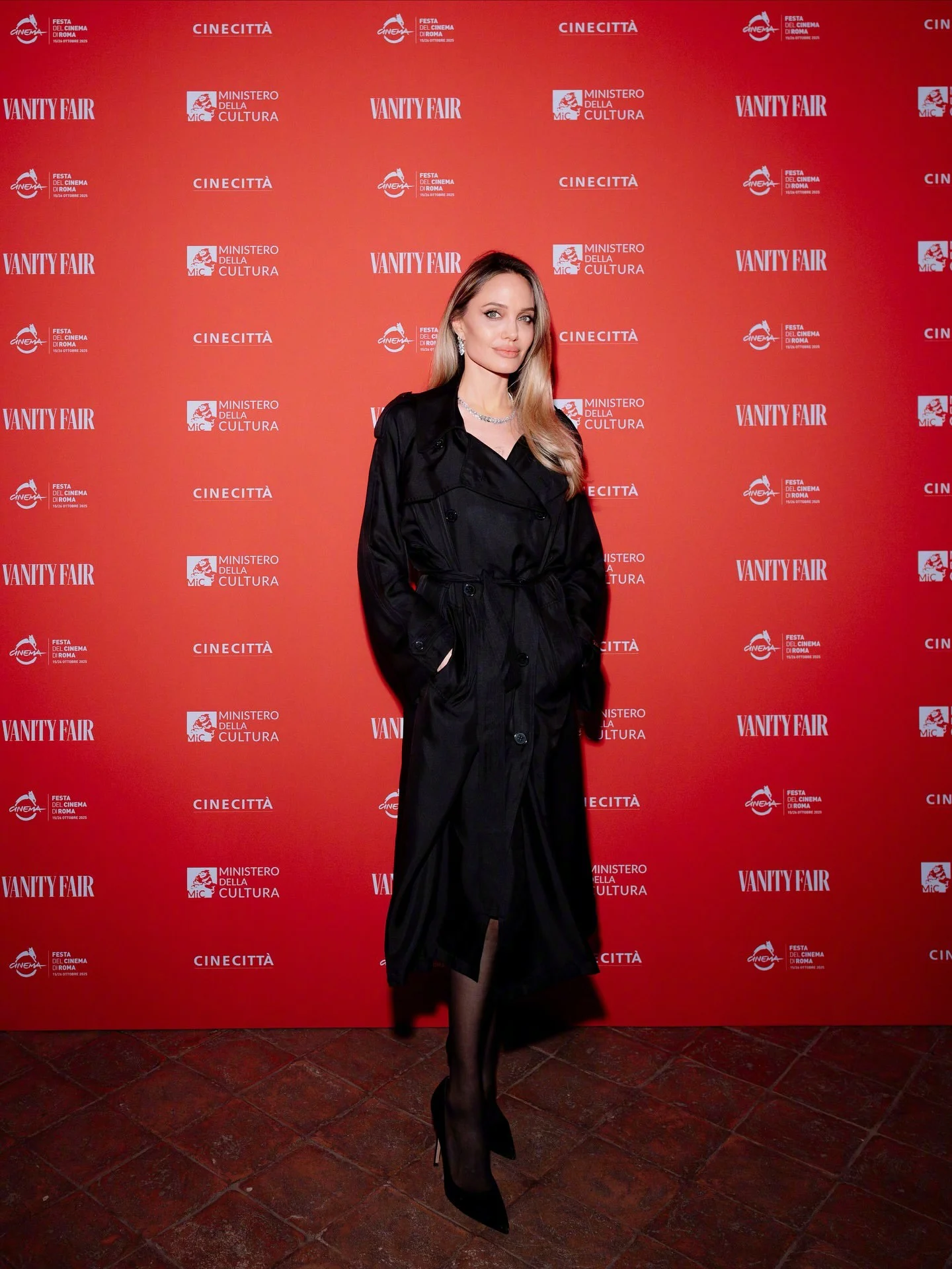 Angelina Jolie. Timeless Elegance in a Black Trench Coat and Monochrome Accessories