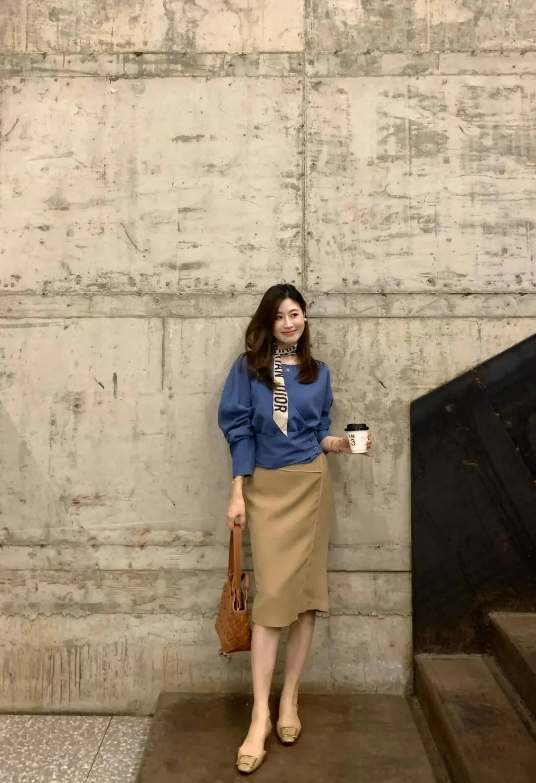 Sophisticated Blue Blouse and Beige Skirt Outfit Featuring Stylish Scarf and Woven Bag