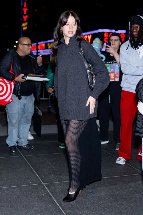 Mia Goth Has a Unique Temperament. Chic Urban Evening Look with Oversized Sweater and Pleated Skirt