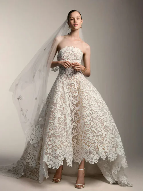 Oscar de la Renta Bridal Fall 2026. Elegant Strapless Lace Wedding Dress with Modern High-Low Hemline