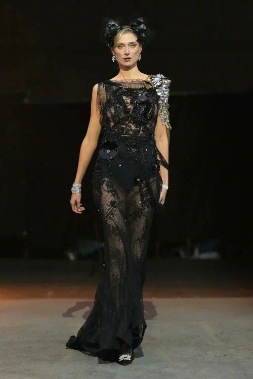 Elegant Black Lace Gown with Metallic Shoulder Embellishments at Fashion Show
