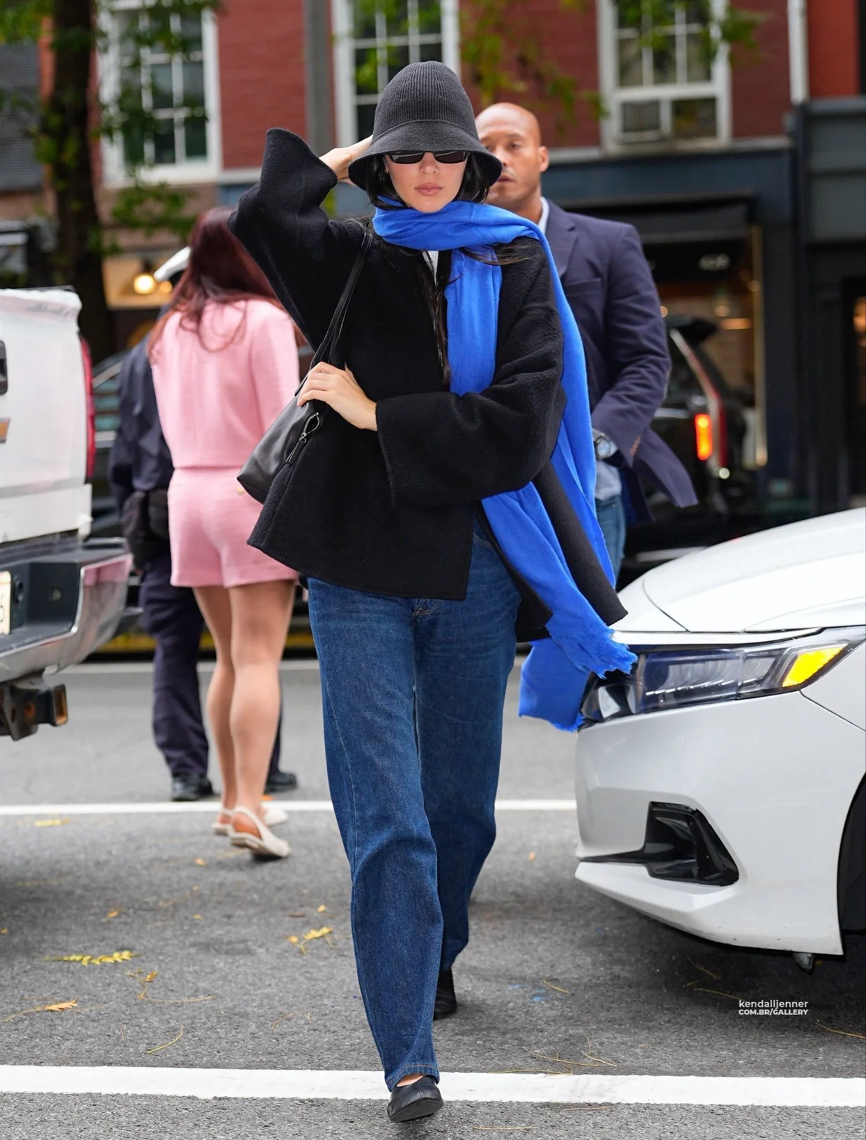 Kendall Jenner was spotted in New York City, wearing a minimalist black jacket paired with a blue scarf.