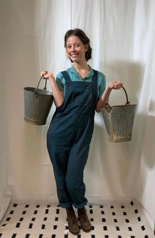 Mia Goth's Costume Fitting Photos for Pearl: Rustic Denim Overalls with Blue-Green Plaid Shirt and Brown Boots