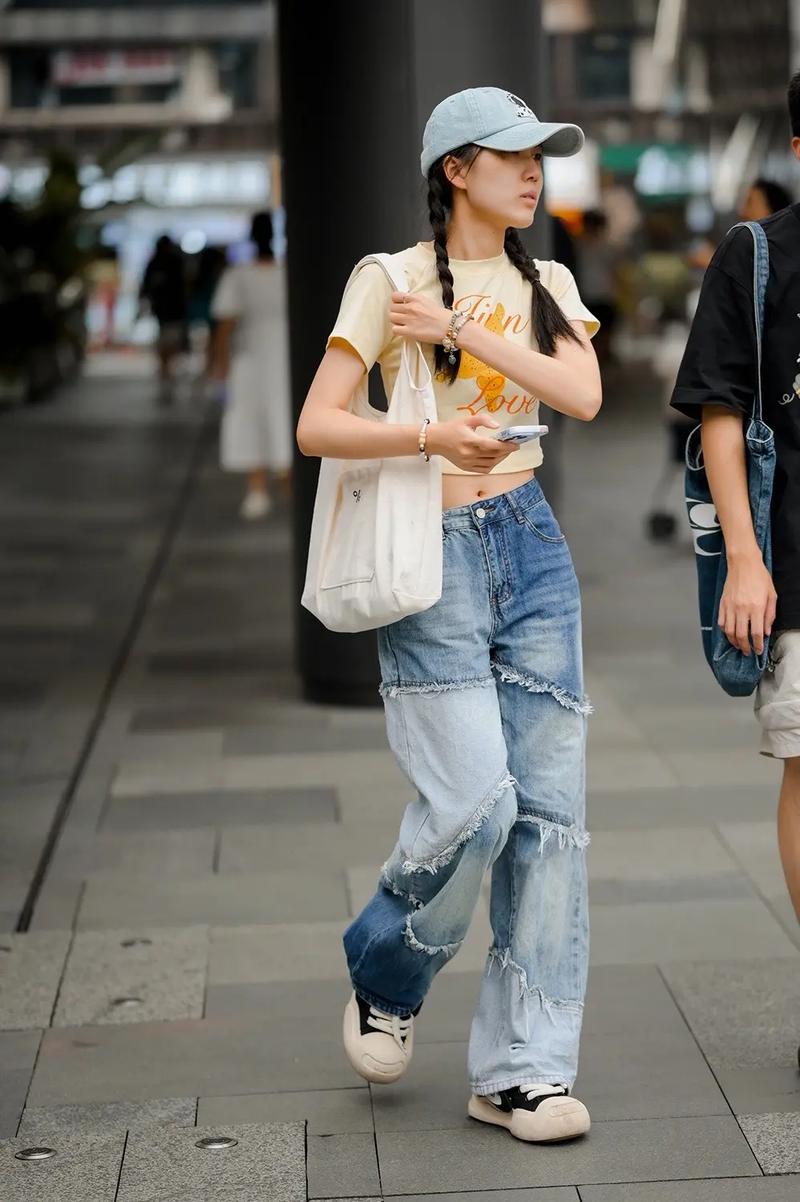 A cool summer street style — crop top, patchwork jeans, and  baseball cap